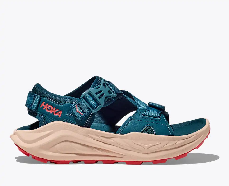 Blue sandal with beige sole and red accents on a white background